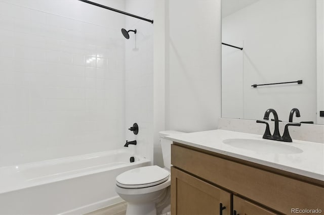 full bathroom featuring tiled shower / bath, vanity, and toilet