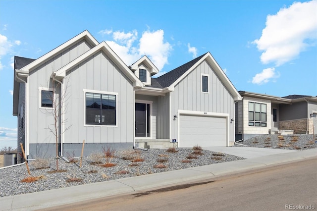 modern farmhouse featuring central air condition unit, board and batten siding, a garage, and driveway