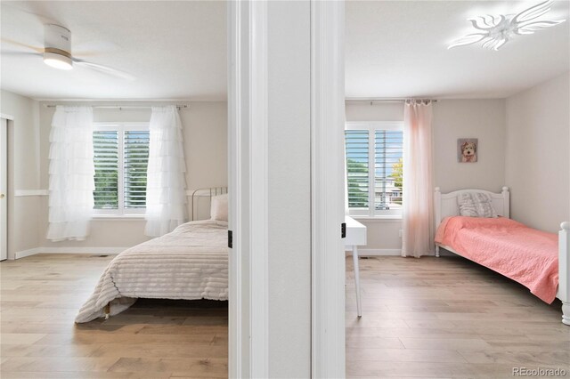 9169 Fox Fire Way, Highlands Ranch, CO 80129 - bedroom featuring multiple windows, wood finished floors, and baseboards