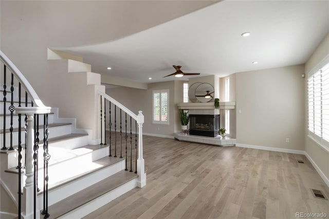 9169 Fox Fire Way, Highlands Ranch, CO 80129 - unfurnished living room with a ceiling fan, stairway, light wood-type flooring, a fireplace, and recessed lighting