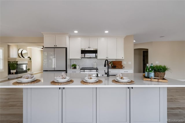 9169 Fox Fire Way, Highlands Ranch, CO 80129 - kitchen featuring white refrigerator, arched walkways, white cabinetry, light countertops, and recessed lighting