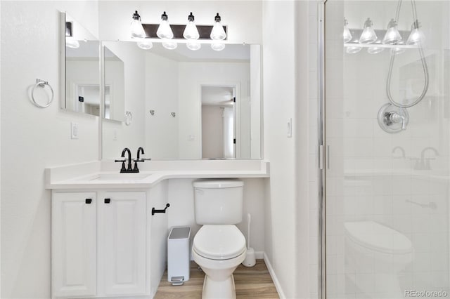 9169 Fox Fire Way, Highlands Ranch, CO 80129 - full bathroom with toilet, a stall shower, vanity, wood finished floors, and baseboards