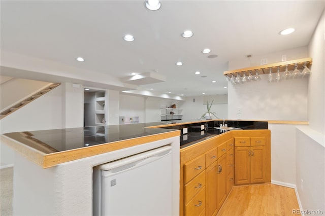 9169 Fox Fire Way, Highlands Ranch, CO 80129 - kitchen featuring white dishwasher, recessed lighting, a peninsula, light wood finished floors, and a sink