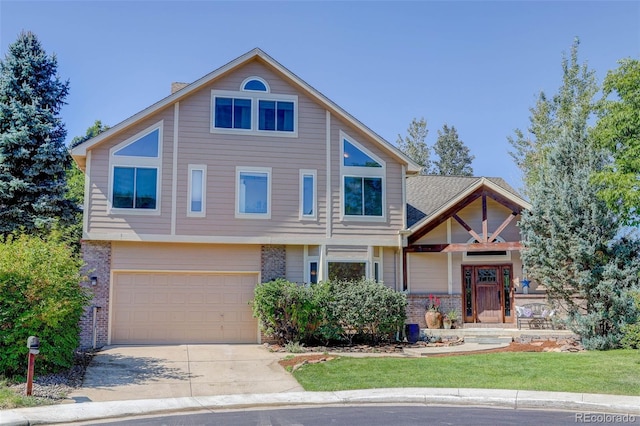 view of front of house with a front yard, a garage, brick siding, and driveway