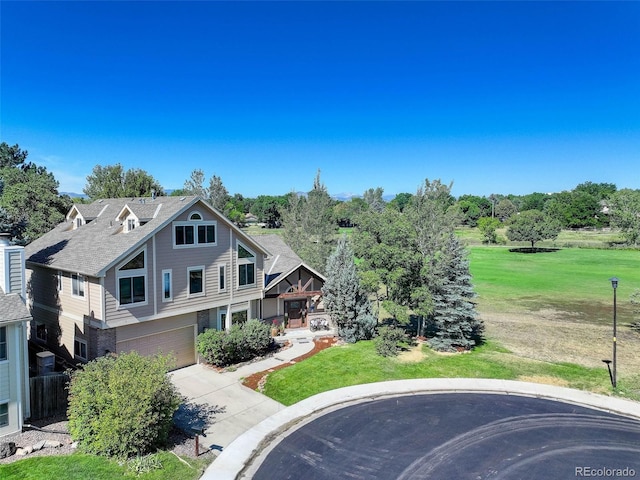 view of front of property featuring a garage, concrete driveway, and a front lawn