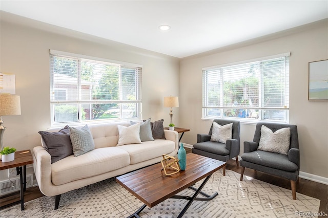 living area with visible vents, baseboards, light wood-type flooring, and a wealth of natural light