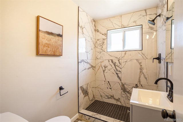 bathroom with a tile shower, toilet, and vanity