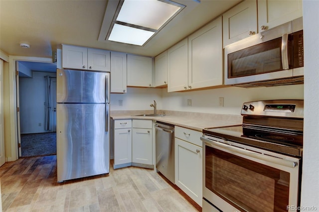 1885 S Quebec Way Unit A16, Denver, CO 80231 - kitchen featuring appliances with stainless steel finishes, light countertops, light wood finished floors, and white cabinets