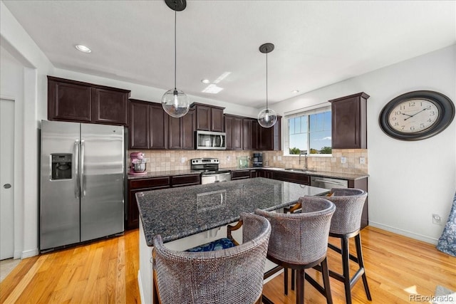 12972 Uinta Ct, Thornton, CO 80602 - kitchen with appliances with stainless steel finishes, dark brown cabinets, backsplash, light wood-style flooring, and recessed lighting