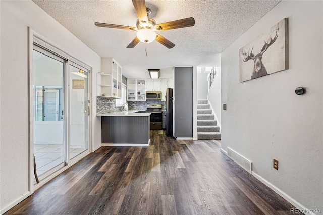 9805 Garrison Ct, Broomfield, CO 80021 - kitchen with stainless steel appliances, open shelves, a peninsula, dark wood finished floors, and a textured ceiling