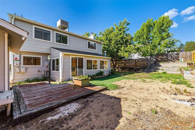 9805 Garrison Ct, Broomfield, CO 80021 - rear view of house with a wooden deck, central AC unit, and a chimney