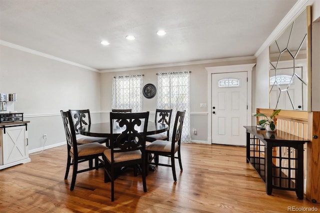 dining room with light hardwood / wood-style floors and crown molding