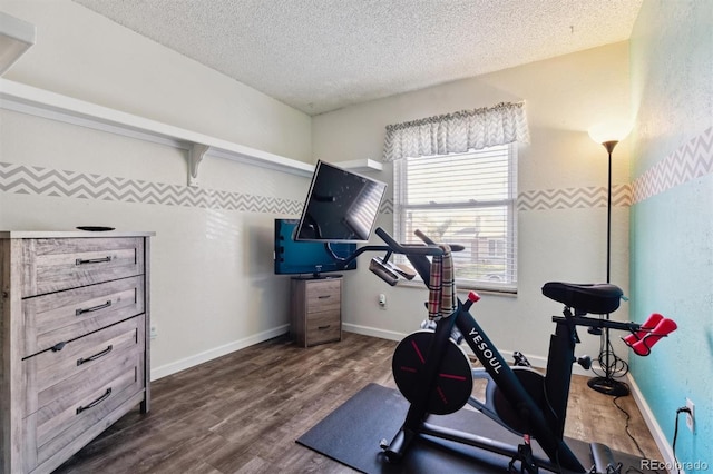 exercise room featuring dark hardwood / wood-style flooring and a textured ceiling