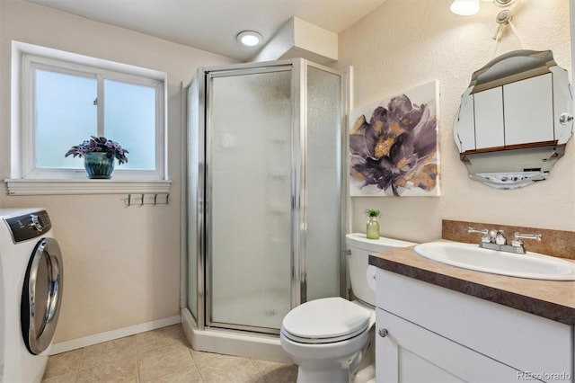 bathroom featuring tile patterned floors, vanity, a shower with shower door, and washer / dryer