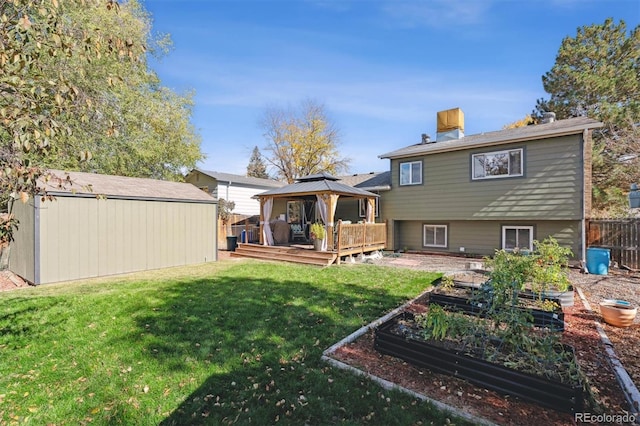 rear view of house featuring a gazebo, a yard, a deck, and a storage unit