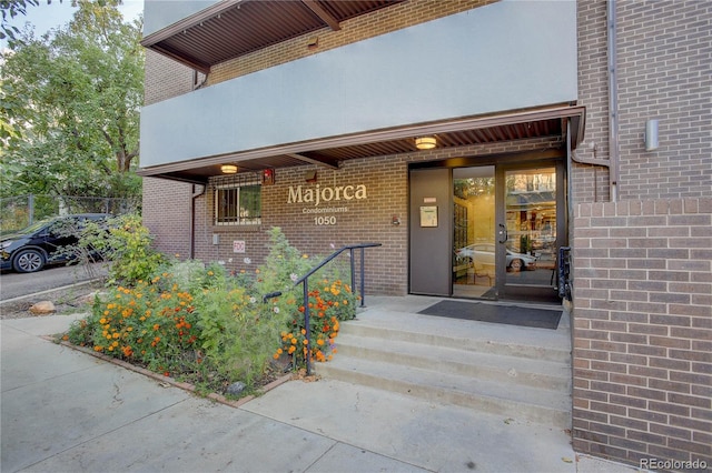 entrance to property featuring brick siding