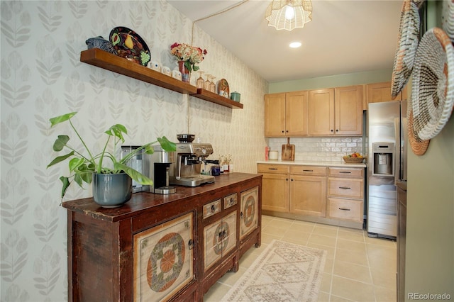 kitchen featuring light brown cabinets, open shelves, stainless steel fridge with ice dispenser, wallpapered walls, and light tile patterned floors