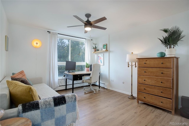 home office with a ceiling fan, baseboards, baseboard heating, and light wood-style flooring