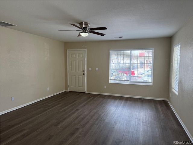 spare room with dark hardwood / wood-style flooring and ceiling fan