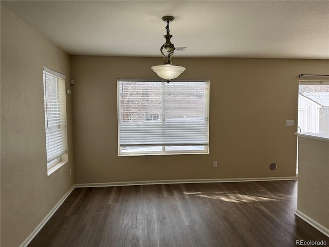 unfurnished dining area with dark hardwood / wood-style flooring