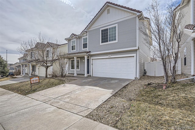 traditional home featuring driveway, an attached garage, and fence