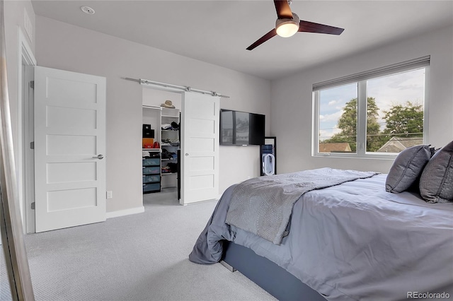 4156 Vrain St, Denver, CO 80212 - carpeted bedroom featuring a walk in closet, a closet, a ceiling fan, and a barn door