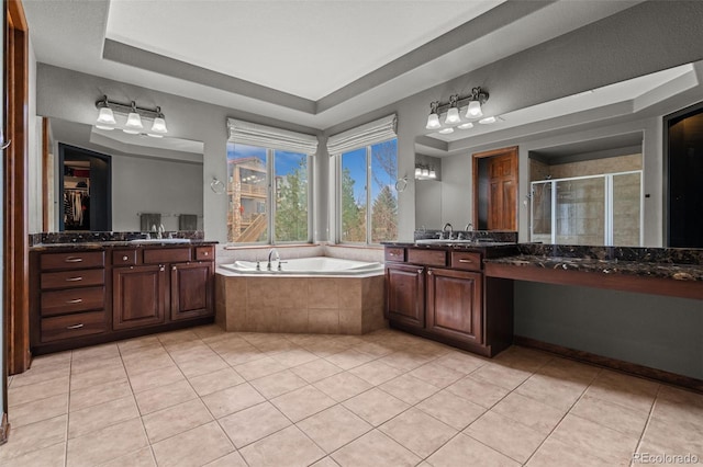 bathroom featuring a shower stall, tile patterned flooring, a bath, and two vanities