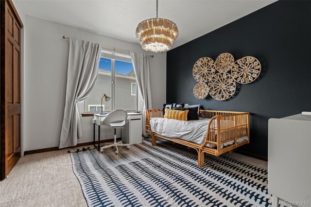 carpeted bedroom featuring a chandelier and baseboards