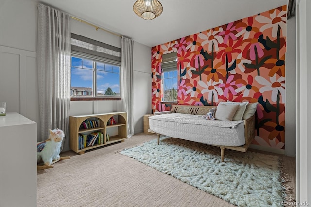 bedroom with carpet flooring and a decorative wall