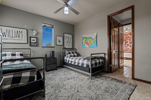 carpeted bedroom featuring baseboards and ceiling fan
