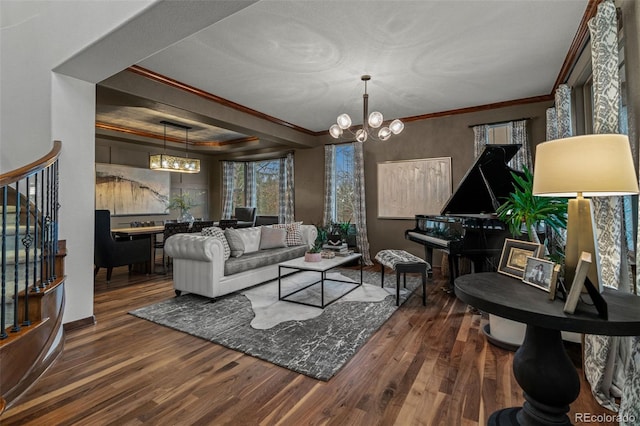 living room with a chandelier, crown molding, wood finished floors, stairway, and baseboards