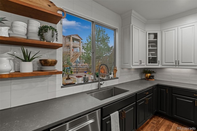 kitchen with a sink, open shelves, dishwasher, dark cabinetry, and dark countertops