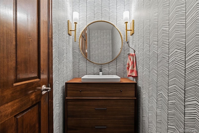 bathroom with wallpapered walls and vanity