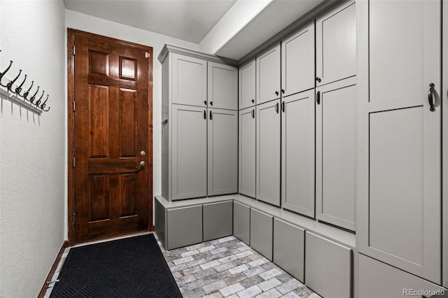 mudroom featuring brick patterned floors