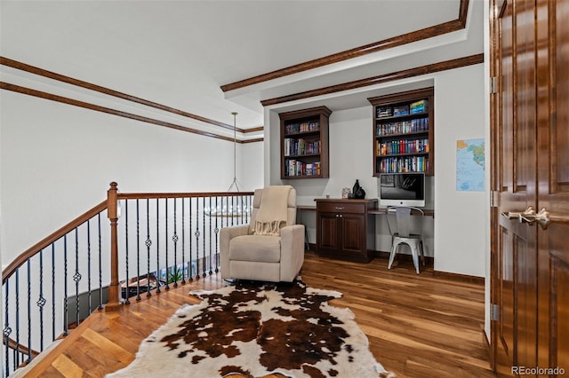 sitting room featuring wood finished floors, ornamental molding, and a desk