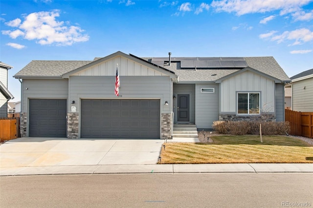 view of front of property with solar panels, a front lawn, and a garage