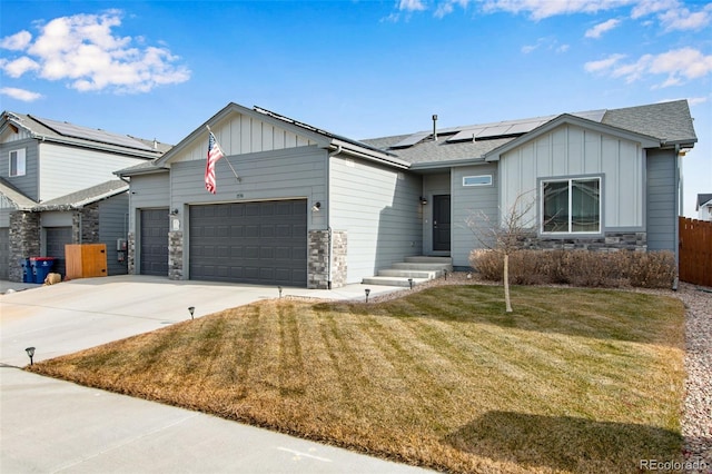 view of front facade featuring a garage, a front yard, and solar panels