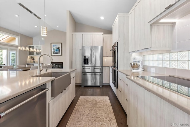 kitchen featuring appliances with stainless steel finishes, modern cabinets, vaulted ceiling, light countertops, and a sink