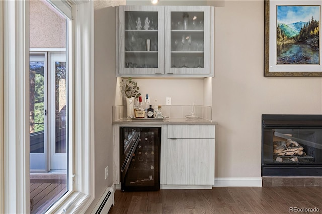 indoor dry bar with wine cooler, plenty of natural light, dark wood-style flooring, and baseboard heating