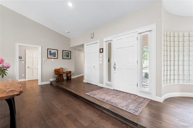foyer featuring wood finished floors, high vaulted ceiling, and baseboards