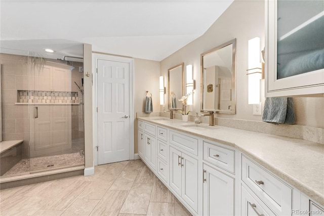 bathroom with a shower stall and double vanity