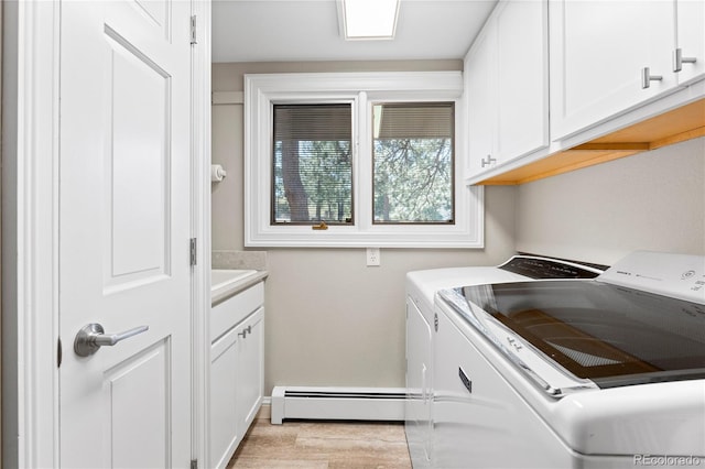 laundry area with washer and clothes dryer, cabinet space, a baseboard radiator, and light wood-style flooring