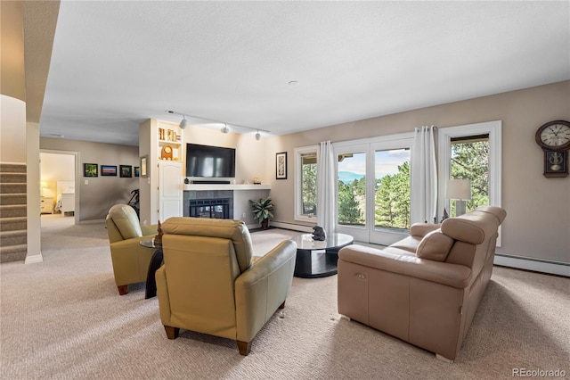living area with light colored carpet, baseboard heating, and healthy amount of natural light