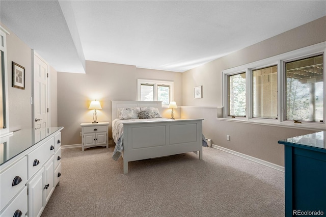 bedroom with light colored carpet and baseboards