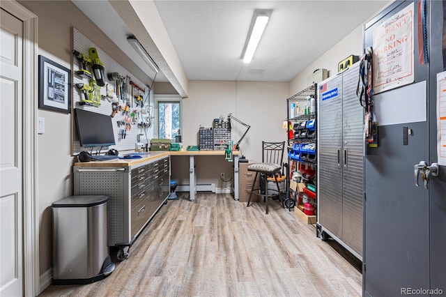 office space featuring light wood-style floors and a baseboard radiator