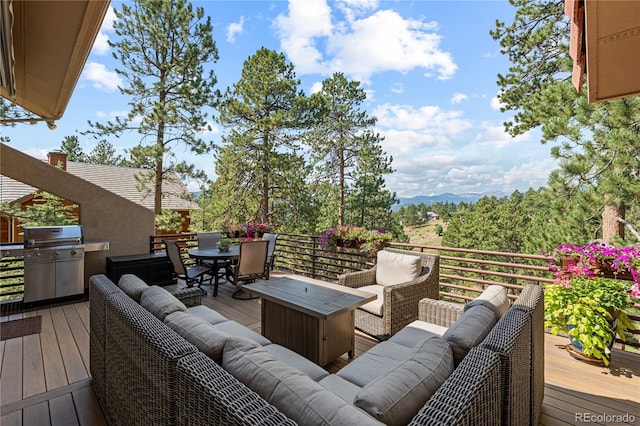 deck with outdoor lounge area, grilling area, and outdoor dining space