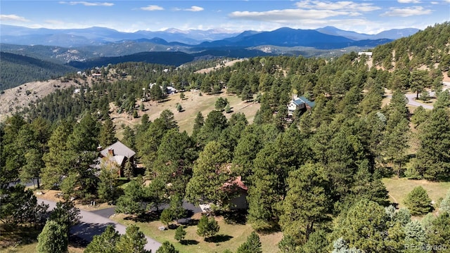 aerial overview of property's location featuring a mountainous background and a heavily wooded area