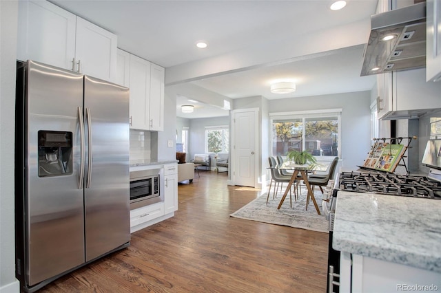 kitchen with light stone counters, white cabinetry, stainless steel appliances, and dark hardwood / wood-style floors