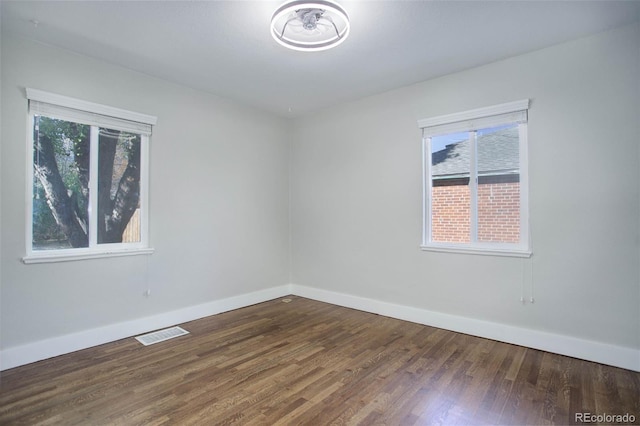 spare room with dark hardwood / wood-style flooring