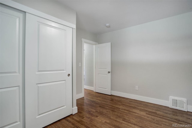 unfurnished bedroom featuring dark hardwood / wood-style floors and a closet